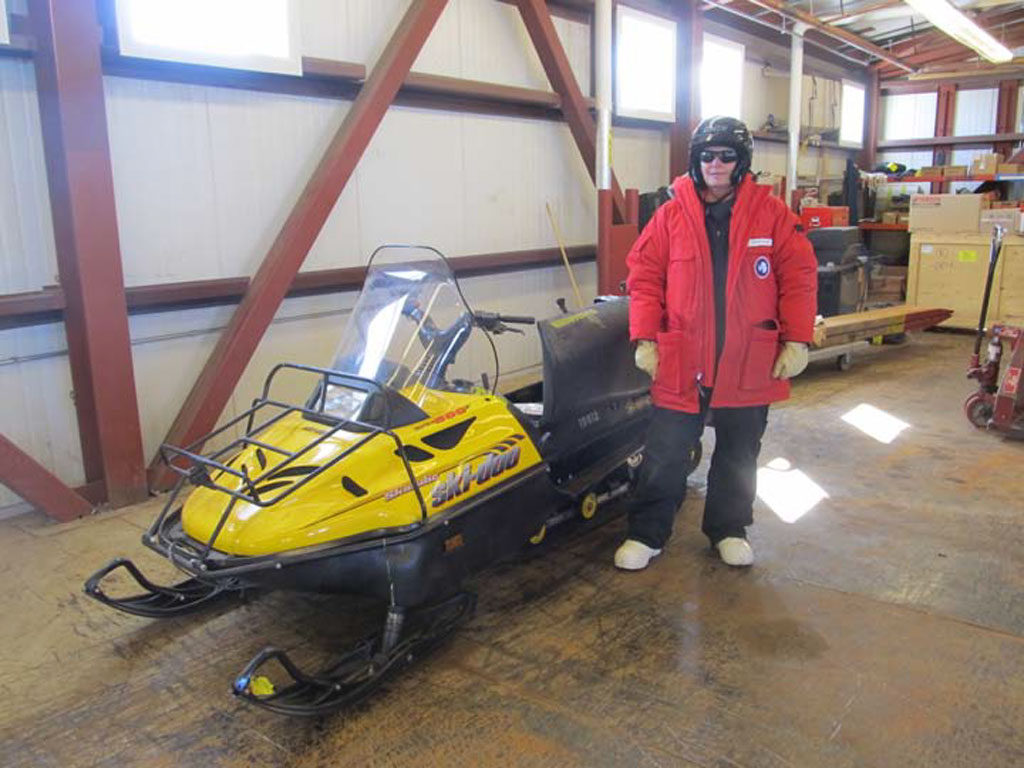Christine Floss, Ph.D., dressed for Antarctic weather, poses with her SkiDoo.